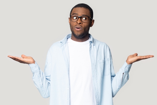 A homeowner shrugs his shoulders with his hands raised confused as to why metal roofs are popular.